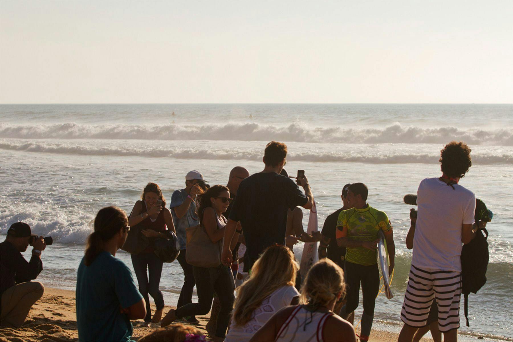surfer gabriel medina surrounded by fans on the beach after a heat