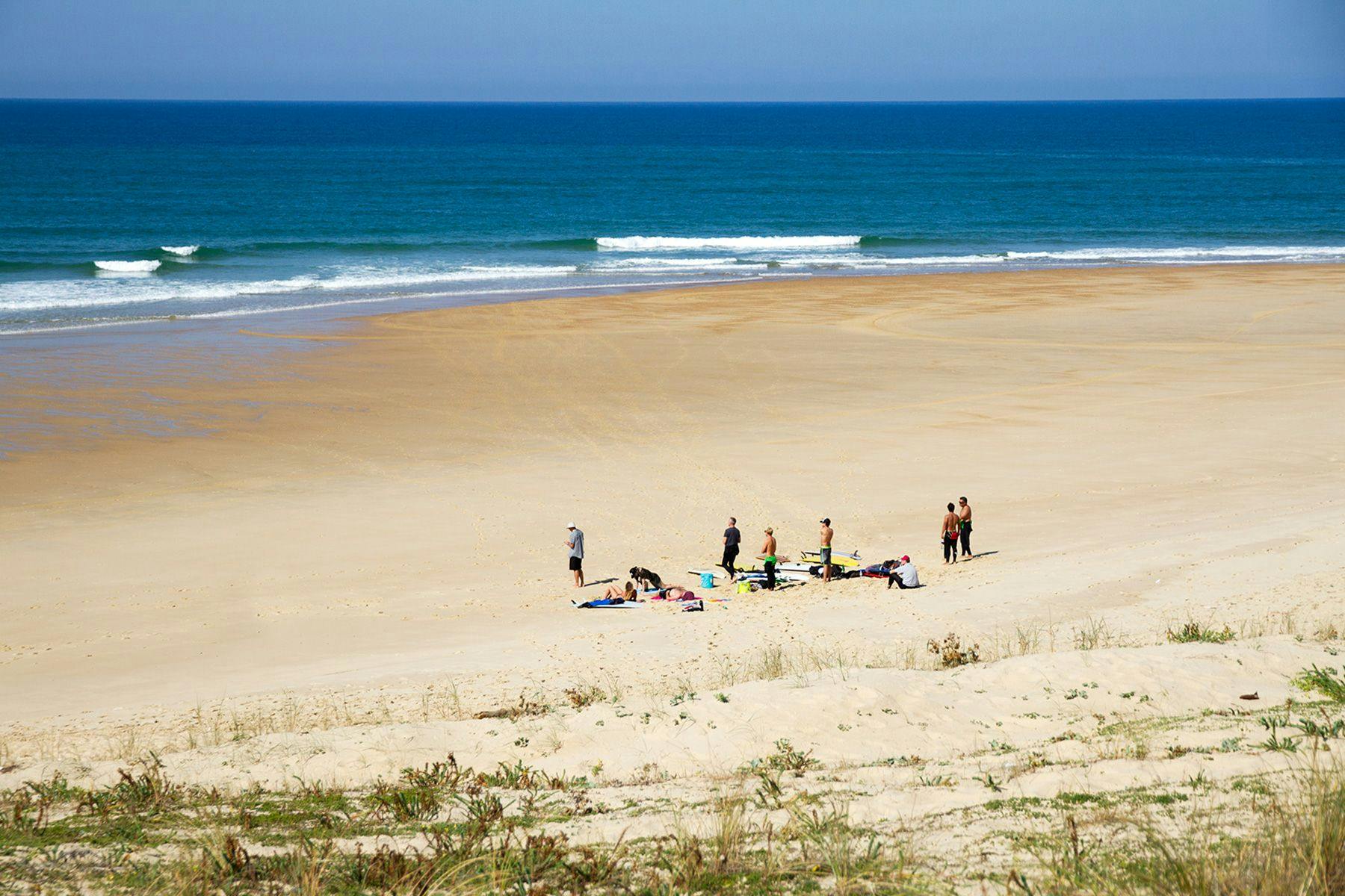 surfers gathered on an empty beach