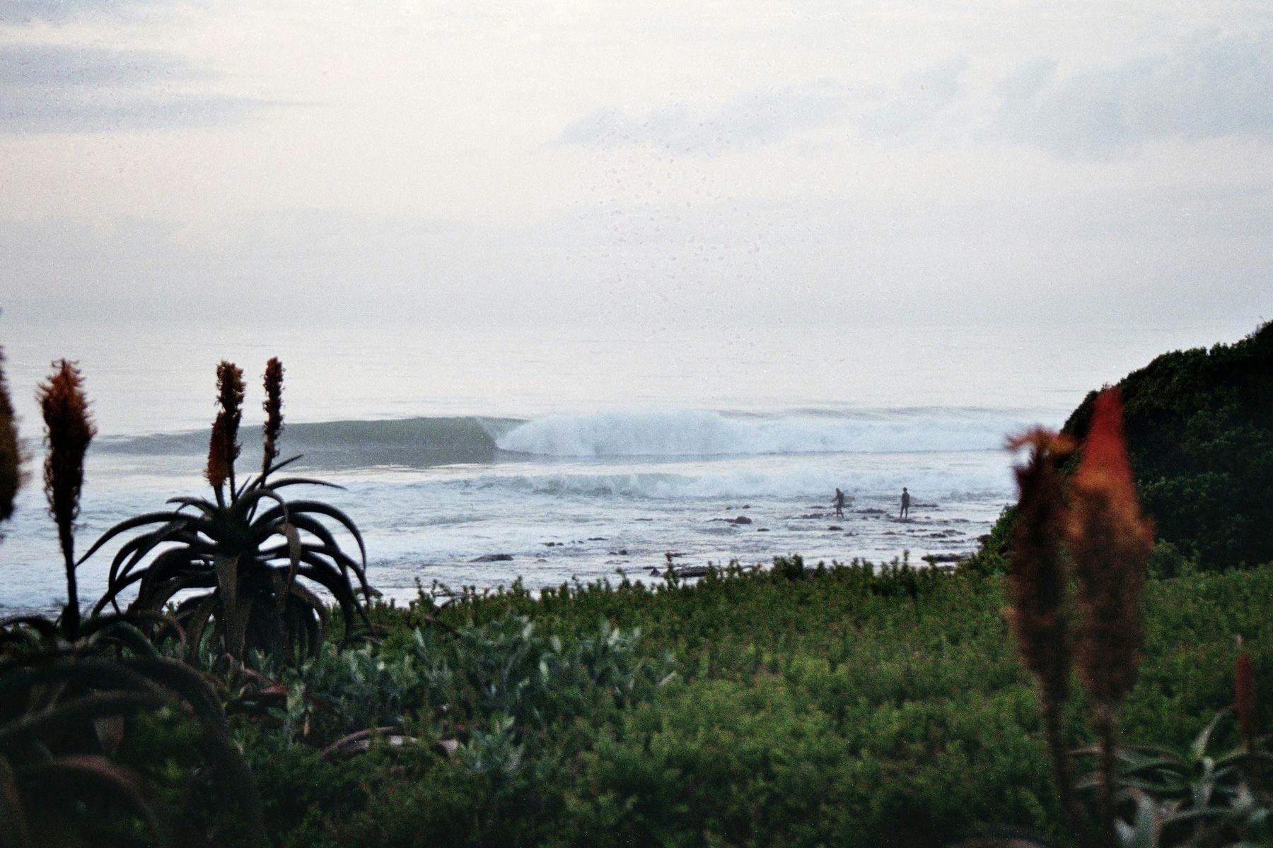 two surfers entering the sea at supertubes, jeffreys bay