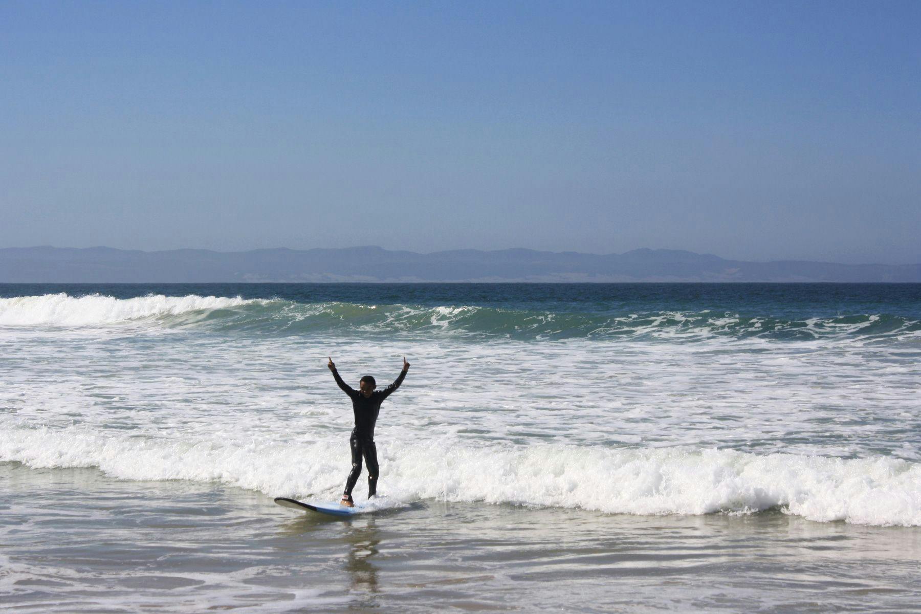 young boy learning to surf in jeffreys bay, soutth africa