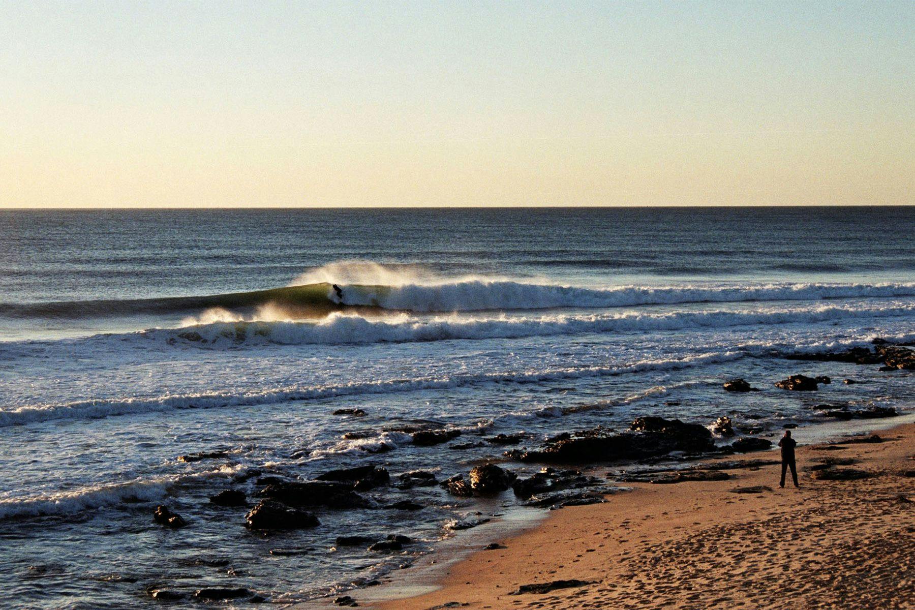 solitary surfer riding a wave at supertubes, jeffreys bay, south africa