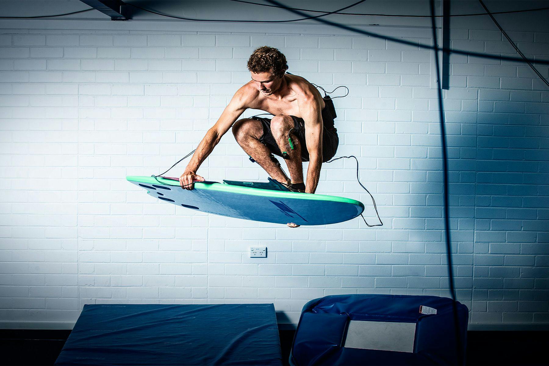 surfer taking part in a scientific study about landing aerial manoeuvres, using a trampoline in a laboratory setting