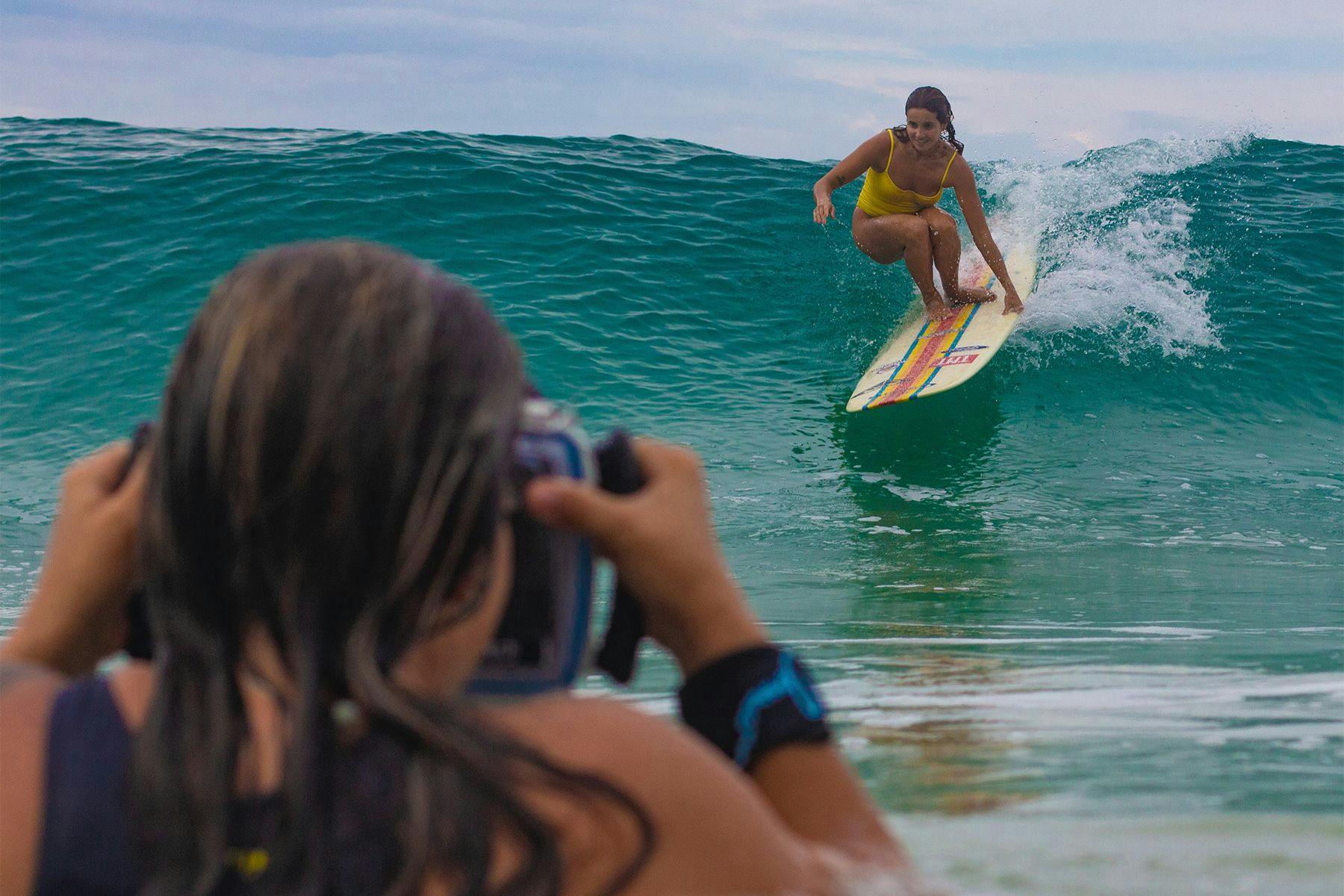 surf photographer ana catarina shooting a female longboarder in the surf