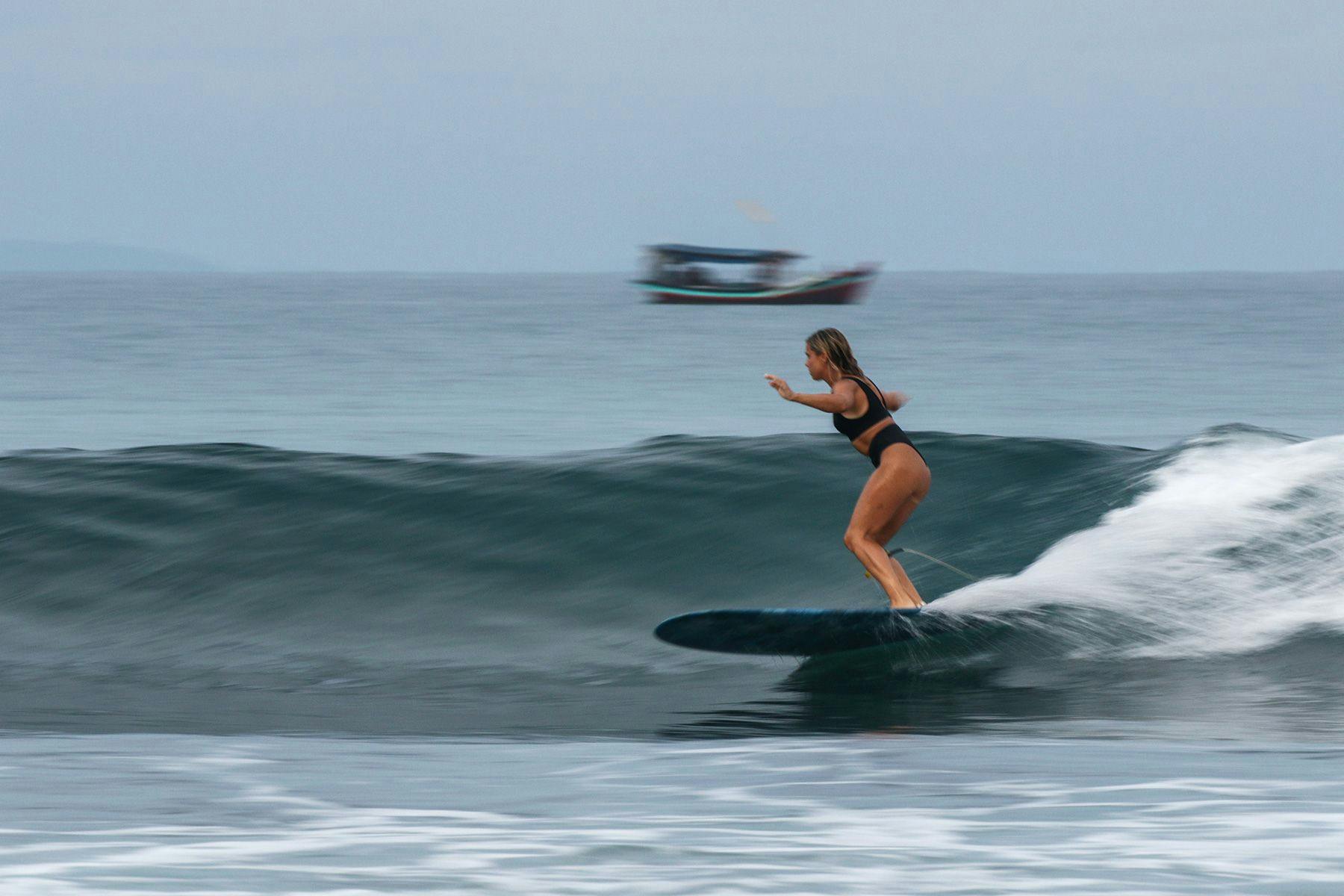 woman surfing in indonesia wearing a noserider surf club bikini