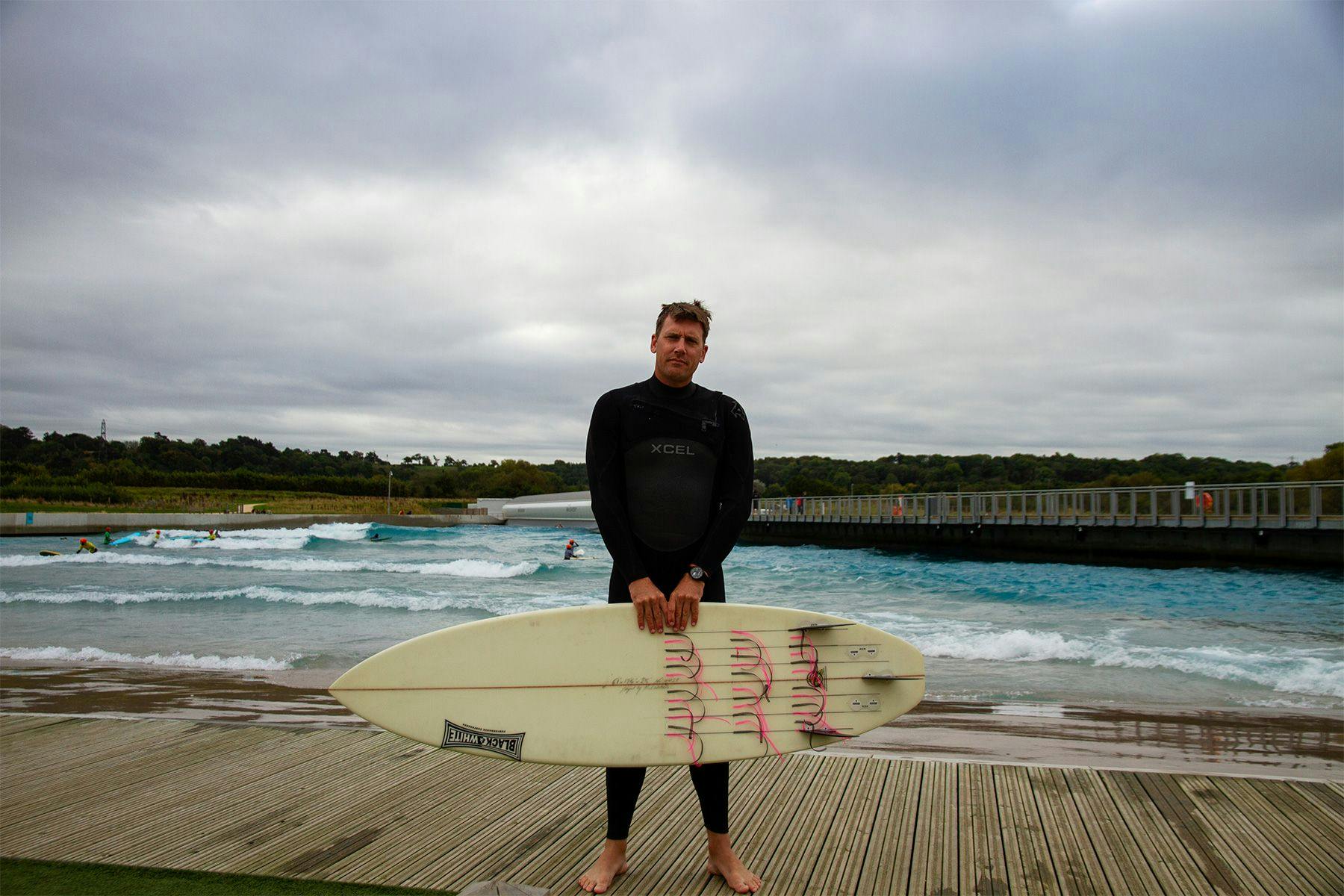 harry knight, director of coaching at surf simply, at the wave inland surf destination in bristol with a surfboard covered in tell tales for an experiment into water flow
