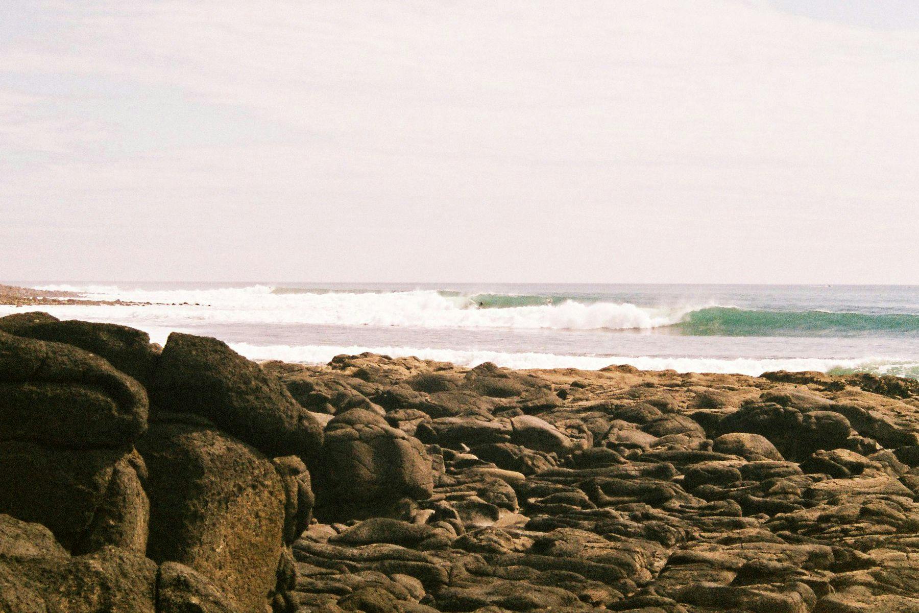 waves breaking at the left hand point break at raglan, new zealand