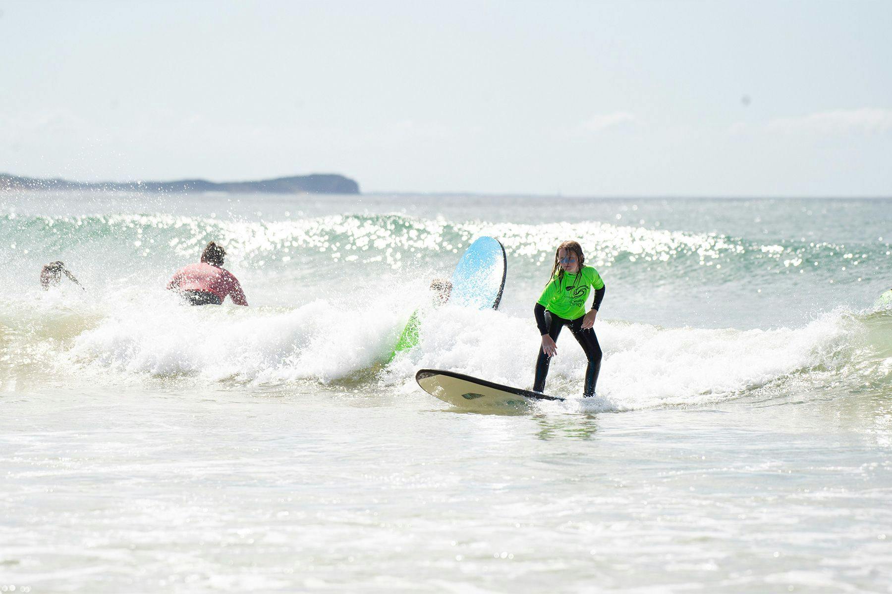 young girl riding a wave during an ocean mind surf session in australia