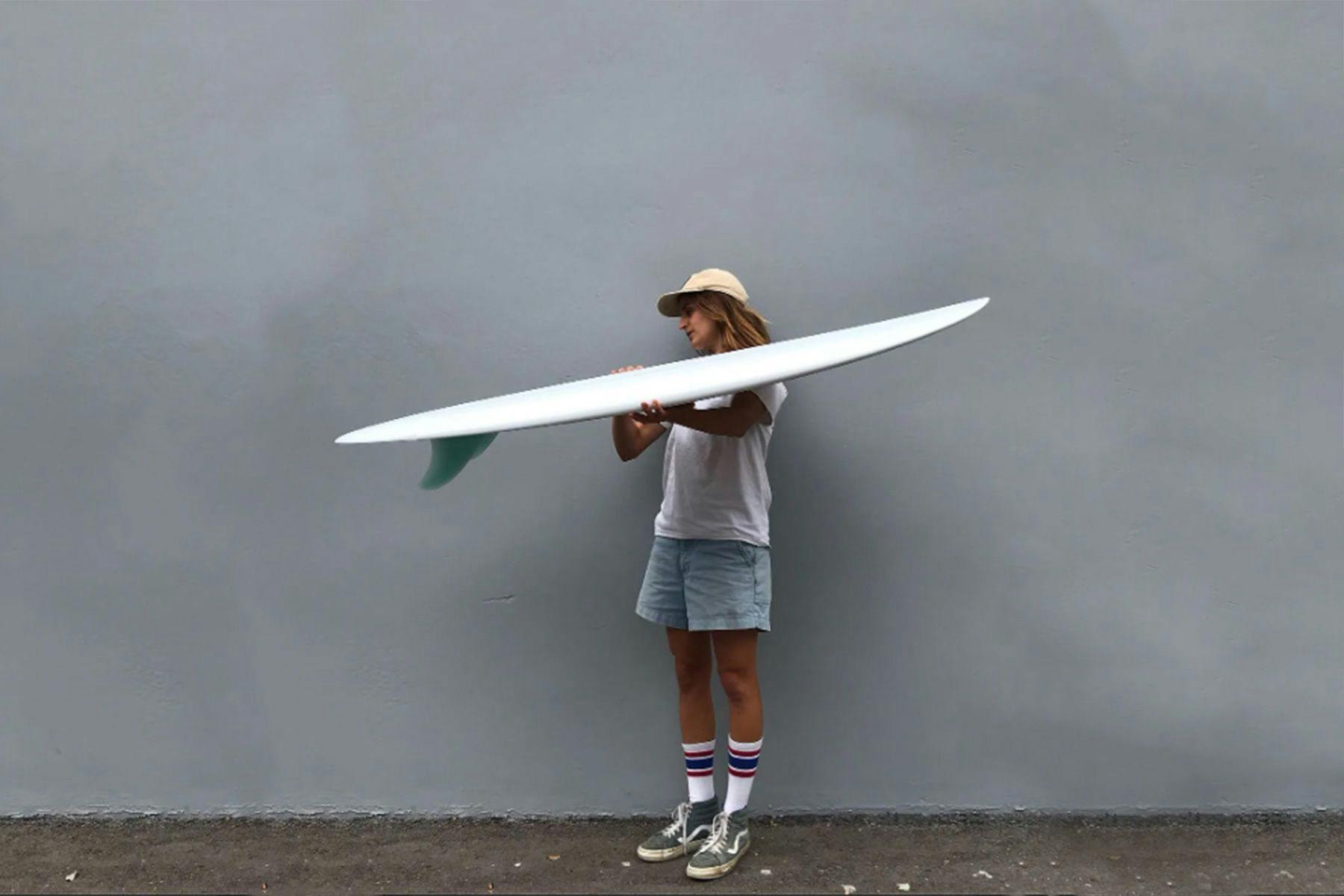 surfboard shaper Christine Brailsford Caroof furrow surfcraft holding up a finished surfboard