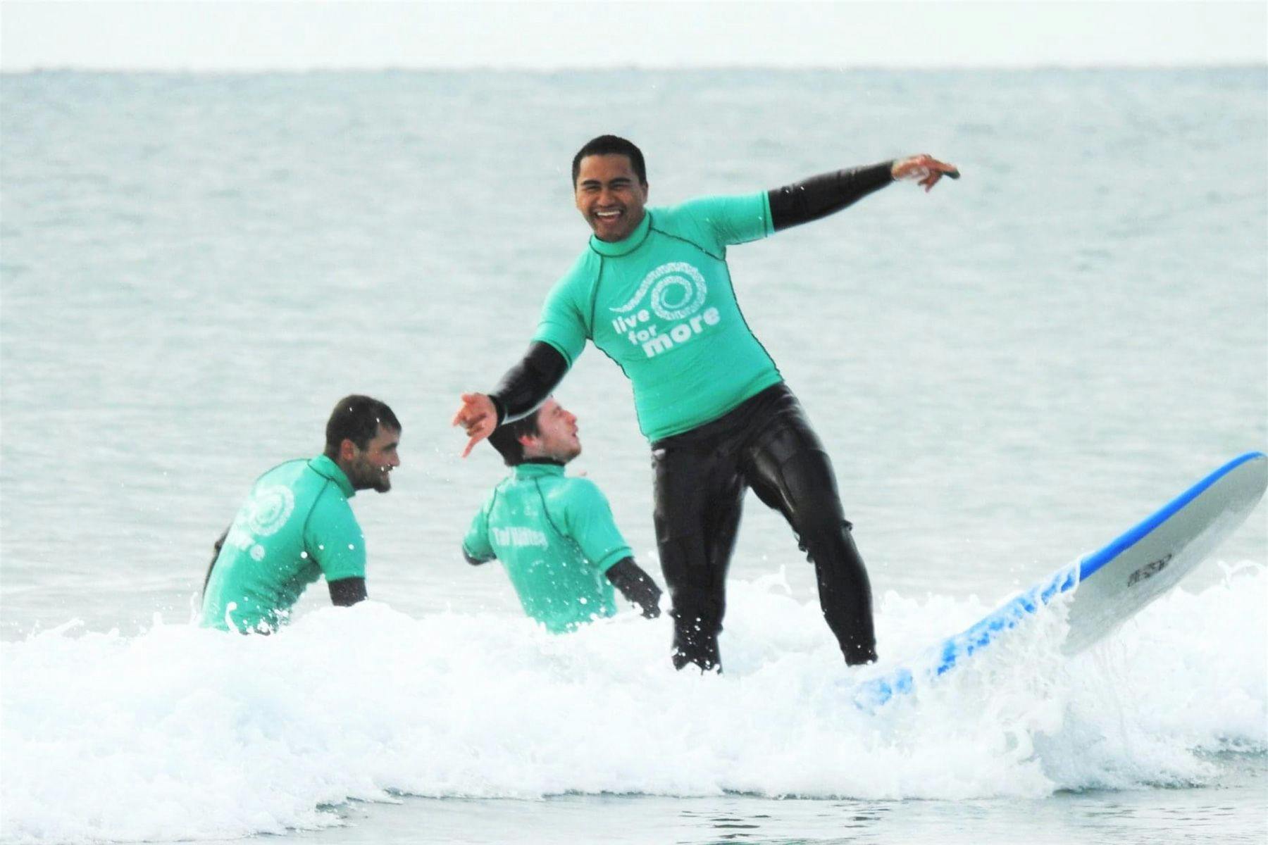 young maori man learning to surf with the the Tai Wātea surf therapy program