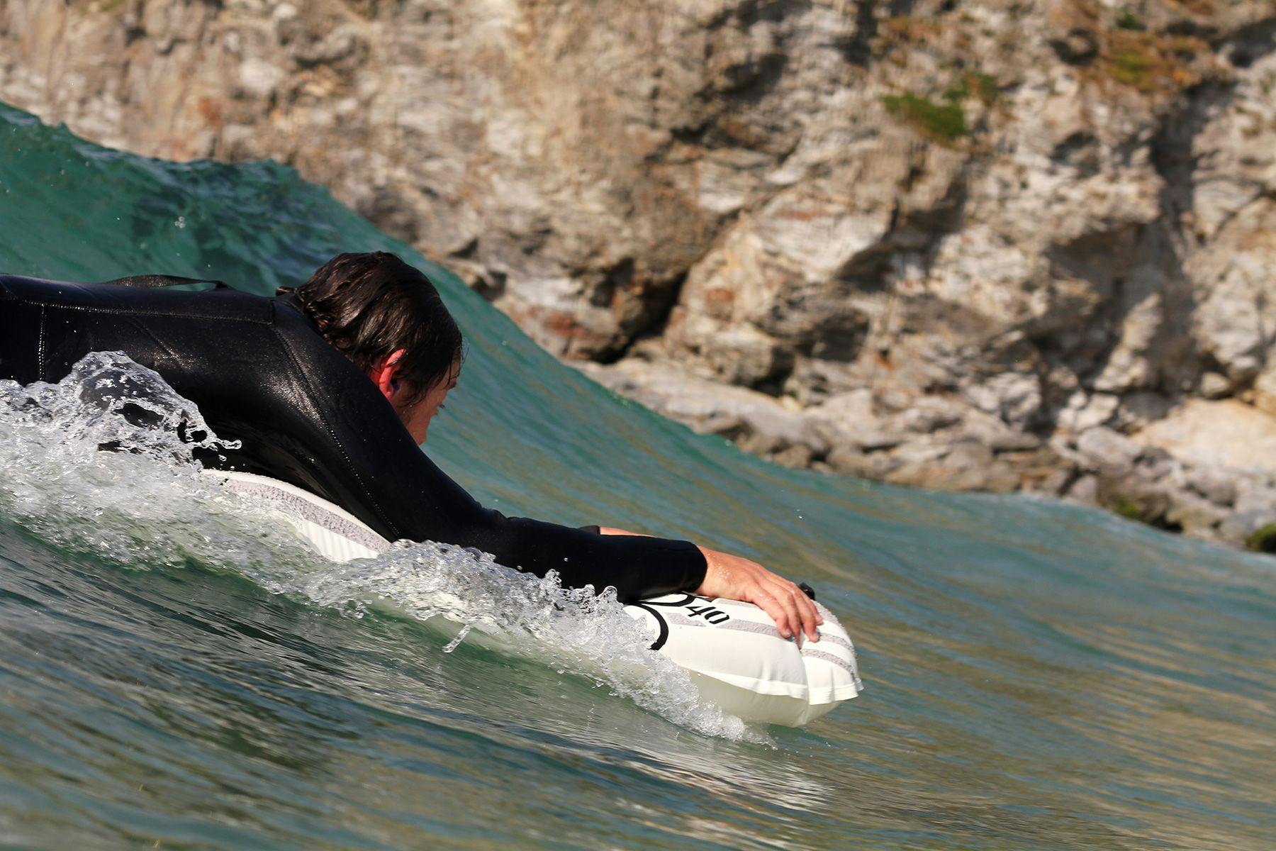 Graeme Webster manipulating his surfmat to the curve of the wave as he drops in. Photographed by Mat Arney.