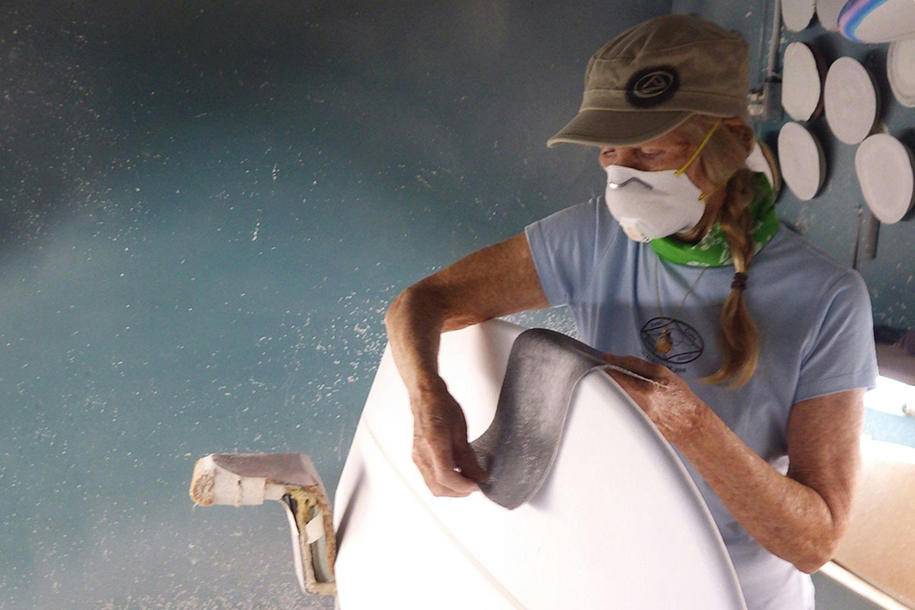 cher pendarvis shaping the rails of a surfboard